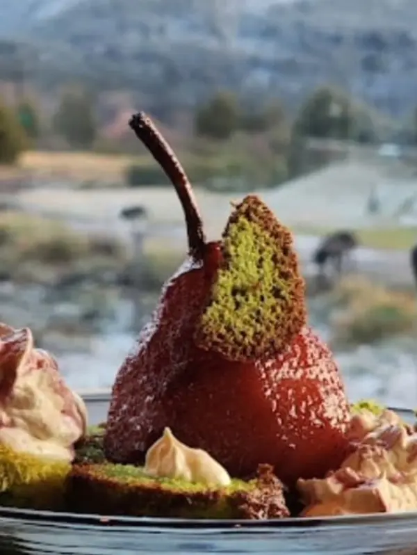 Postre gourmet de peras al vino tinto con salsa regional